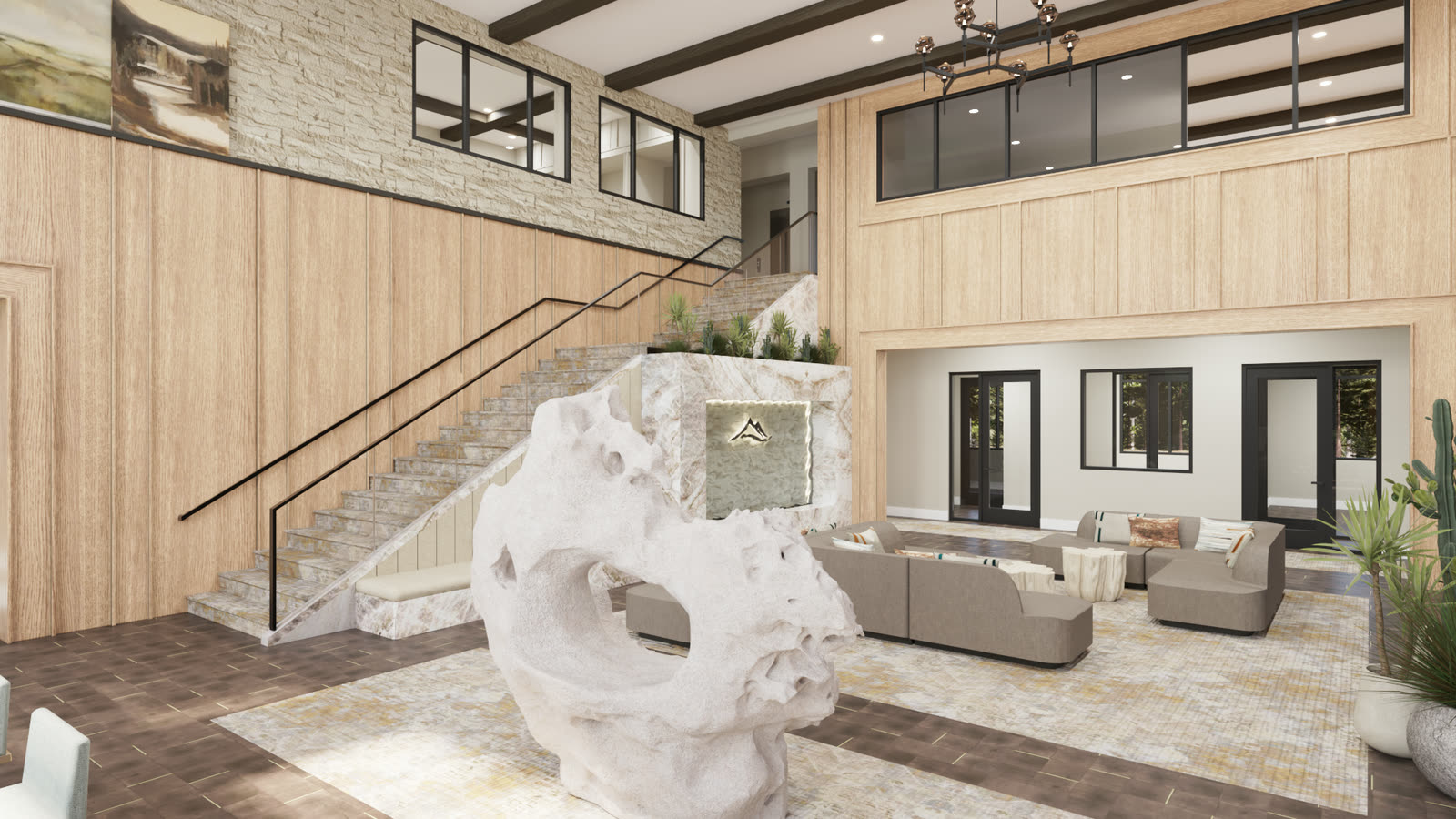 A double height residential lobby with a sculptural stone form at the foot of the stair, timber panelling and a backlit stone feature wall