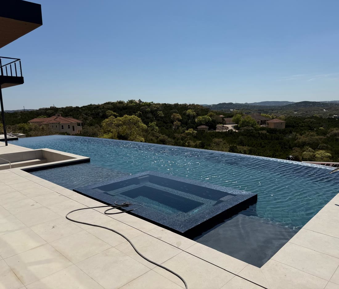 The infinity pool and spa looking out over the hill country in daylight