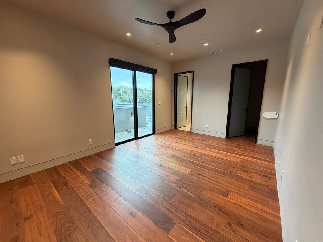 A bedroom in walnut with a sliding door to the terrace