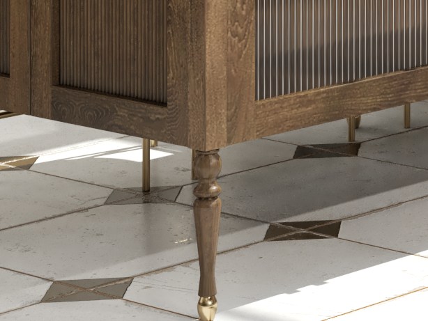 A turned walnut island leg finished with a brass ferrule at the foot, standing on marble and brass floor tiles