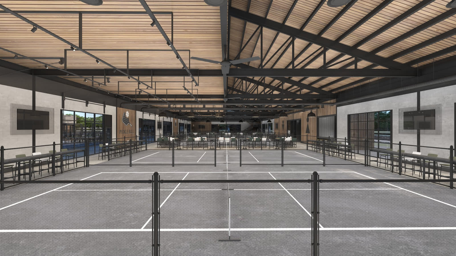 Looking straight down the indoor courts, nets in line, the roof structure overhead