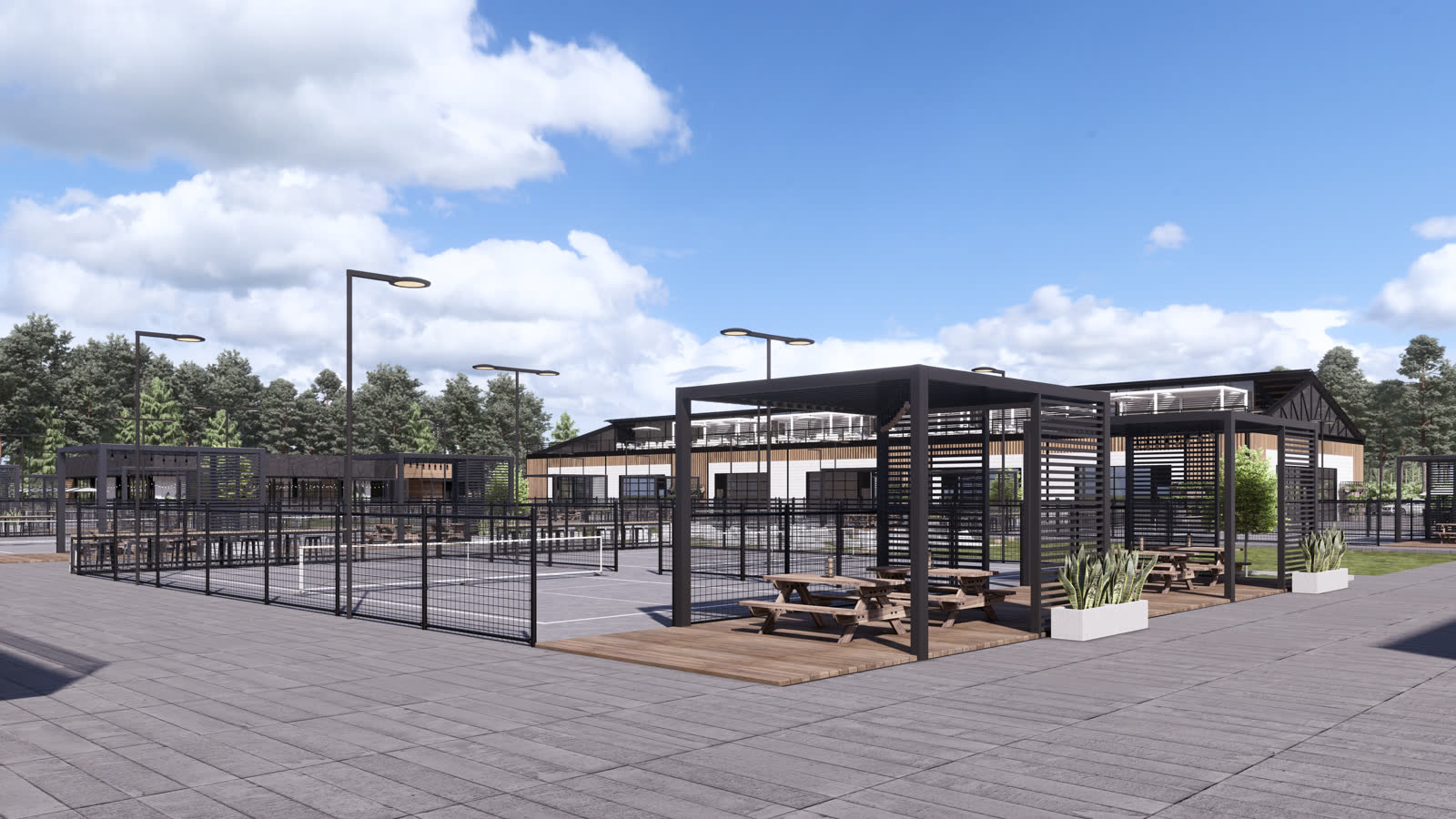 The pergola between the courts: a black steel frame with a slatted roof over picnic tables and planters