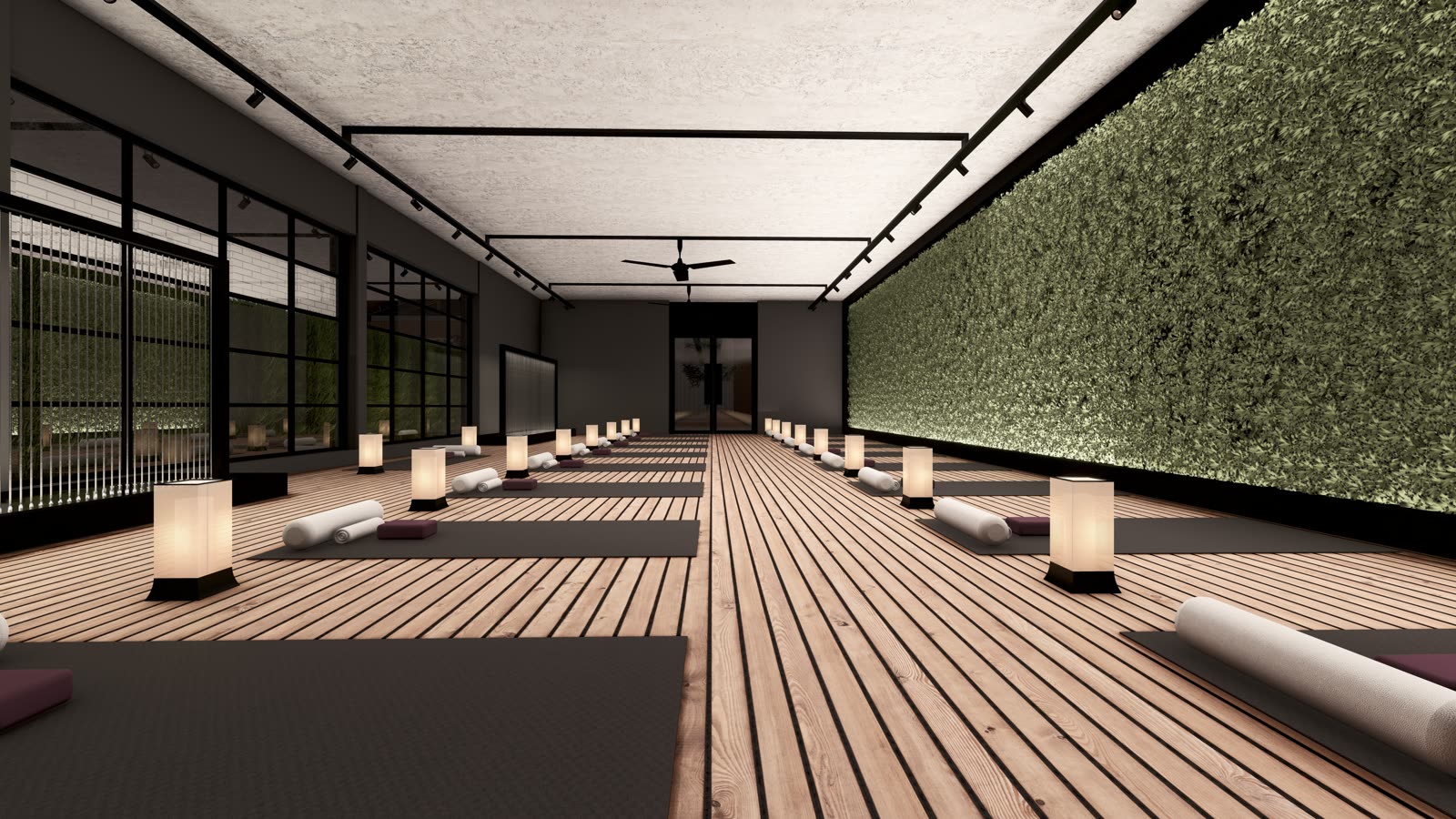 The yoga studio: a timber floor with mats, bolsters and paper lanterns, a living wall on one side and black-framed glazing on the other
