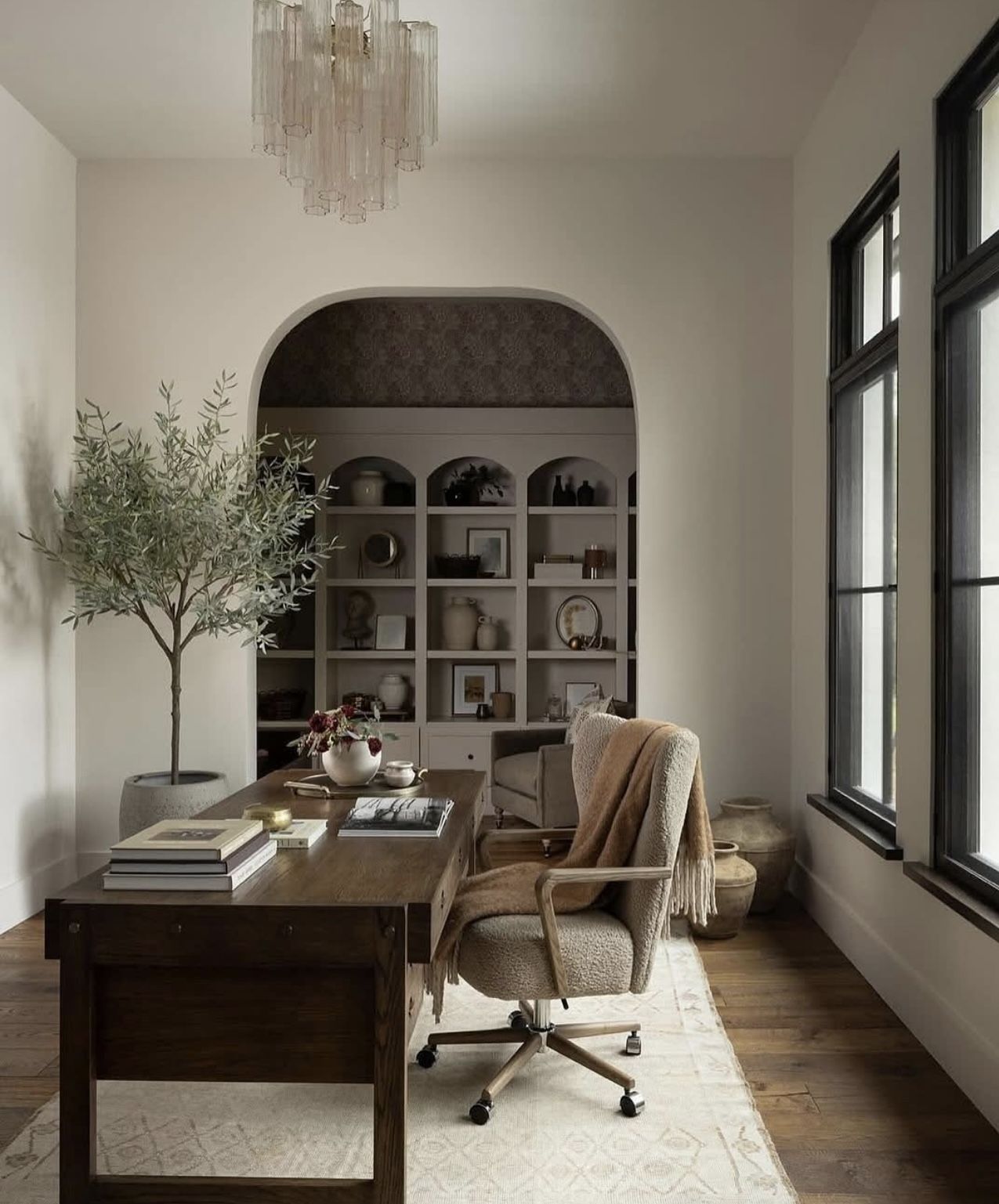 Office or studio, Dark timber desk, arched niche shelving, olive tree, modern