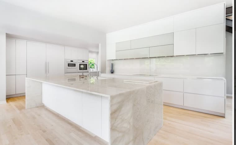 Reference: a white kitchen with a quartzite waterfall island