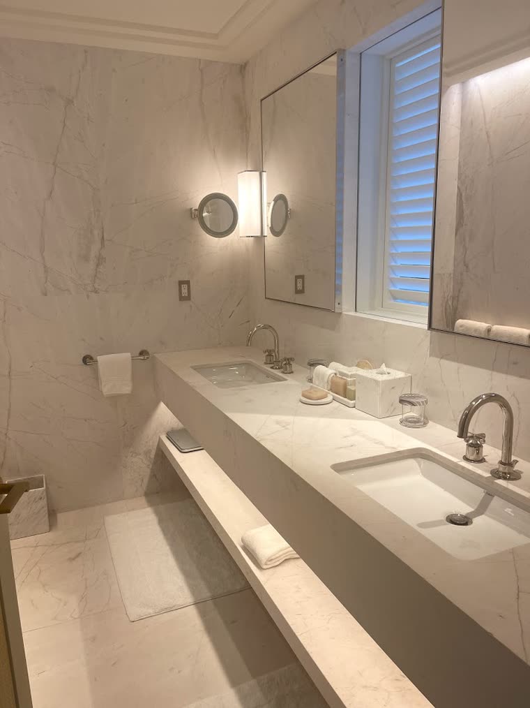 Reference screenshot: a stone bathroom with a long vanity and sconces